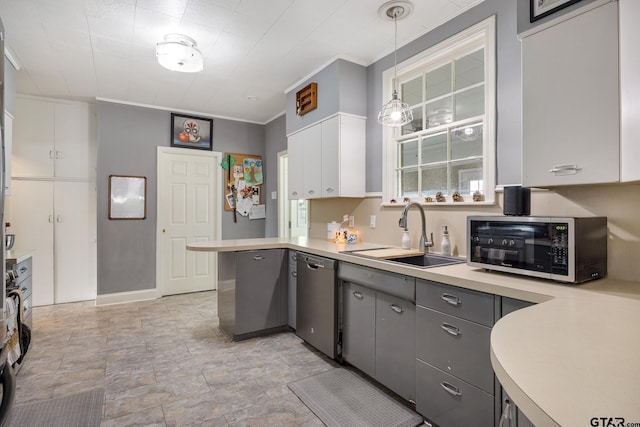 kitchen featuring a peninsula, light countertops, a sink, appliances with stainless steel finishes, and gray cabinetry