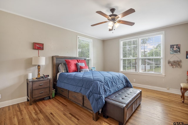 bedroom with baseboards, multiple windows, and light wood-style floors