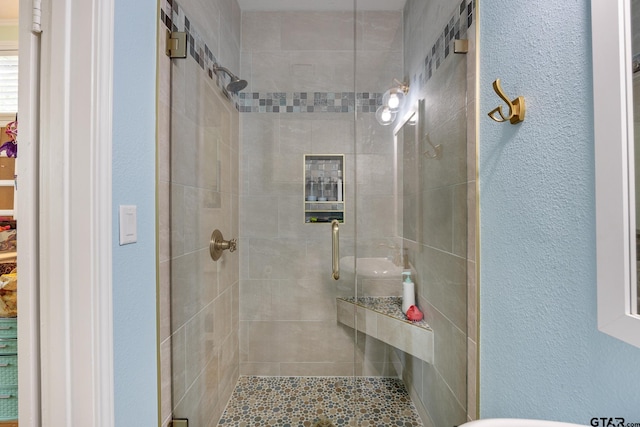 full bath featuring a textured wall and a stall shower
