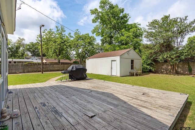 wooden terrace featuring a lawn, a fenced backyard, area for grilling, and an outdoor structure