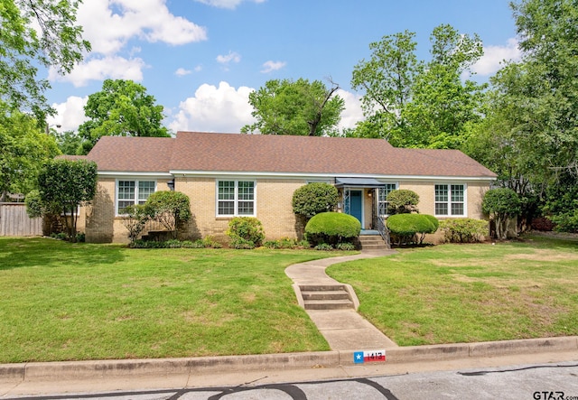 single story home with brick siding, fence, and a front yard
