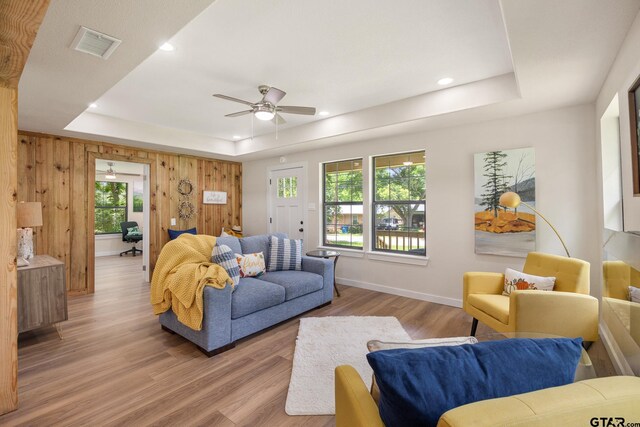 702 W Paschal St, Troup, TX 75789 - living area with a raised ceiling, light wood-style flooring, a ceiling fan, recessed lighting, and wooden walls
