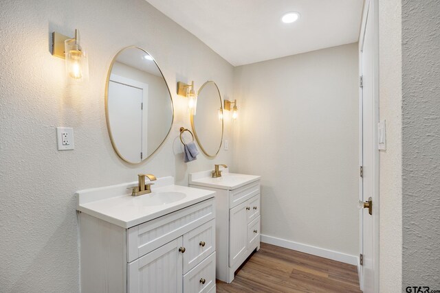 702 W Paschal St, Troup, TX 75789 - bathroom featuring two vanities and wood finished floors