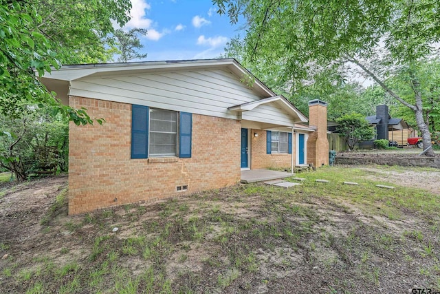 single story home with crawl space, brick siding, and a chimney