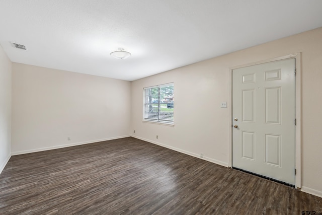 unfurnished room with dark wood-type flooring and baseboards