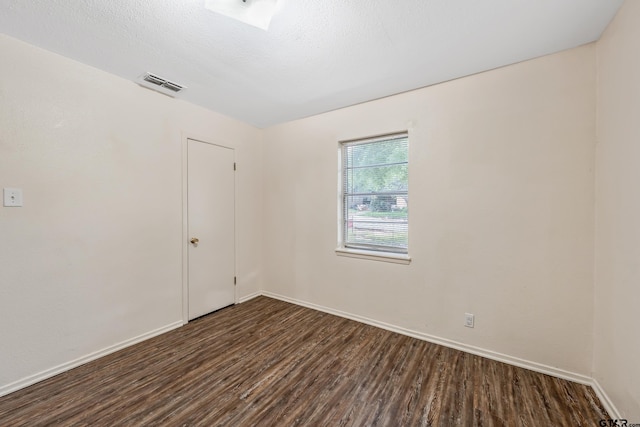 empty room featuring dark wood finished floors and baseboards