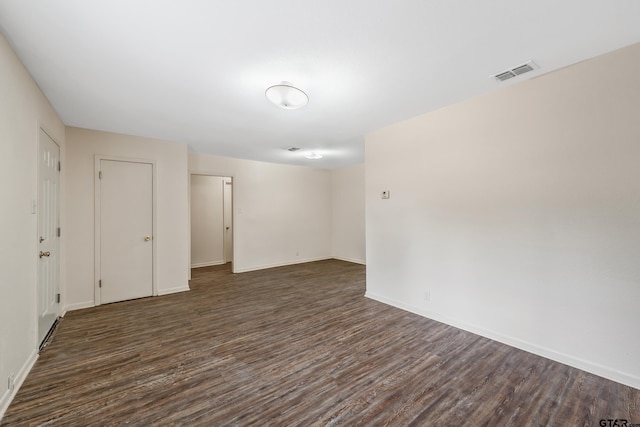 empty room with dark wood finished floors and baseboards
