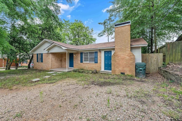 single story home featuring fence, a chimney, and brick siding