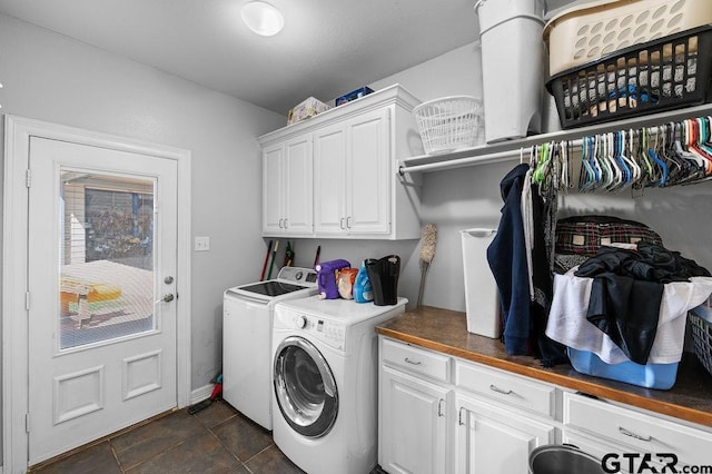clothes washing area featuring washer and clothes dryer and cabinet space