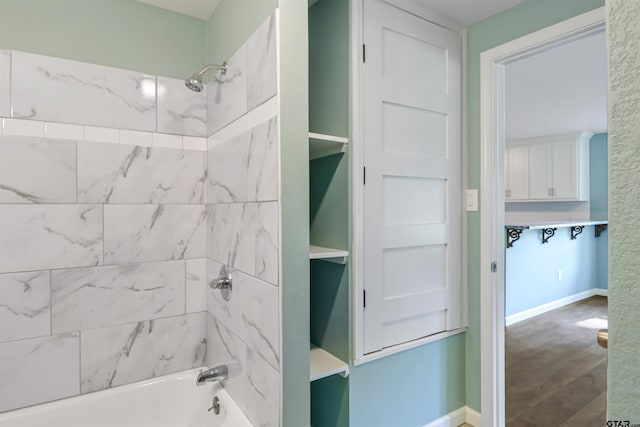 bathroom with tiled shower / bath and wood-type flooring