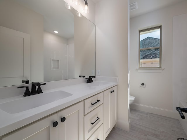 bathroom with hardwood / wood-style floors, vanity, toilet, and a shower