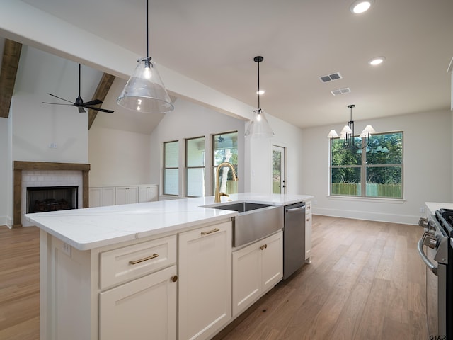 kitchen featuring a healthy amount of sunlight, sink, an island with sink, and stainless steel appliances