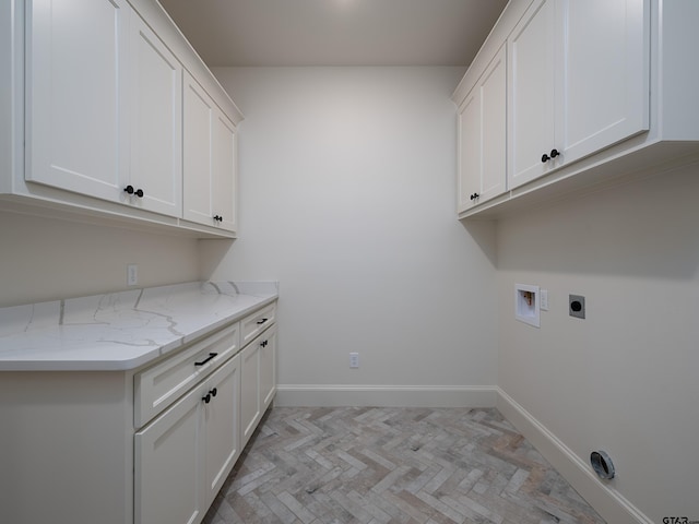 clothes washing area featuring cabinets, washer hookup, light parquet floors, and electric dryer hookup