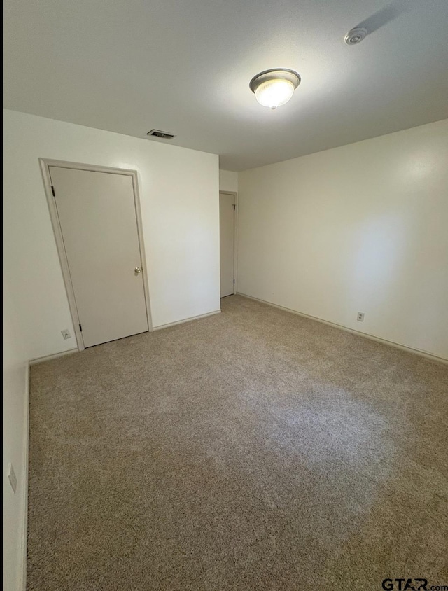 spare room with light colored carpet and baseboards