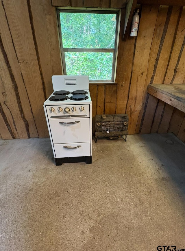 detailed view of white range with electric stovetop, wooden walls, a fire extinguisher, and light carpet