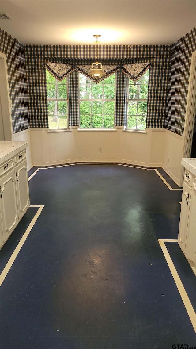 spare room with healthy amount of natural light and baseboards