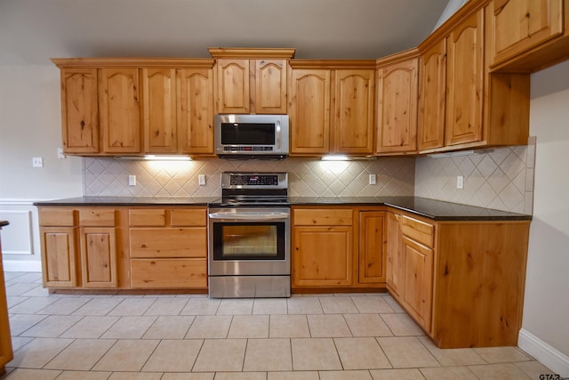 kitchen with tasteful backsplash, appliances with stainless steel finishes, and light tile patterned floors