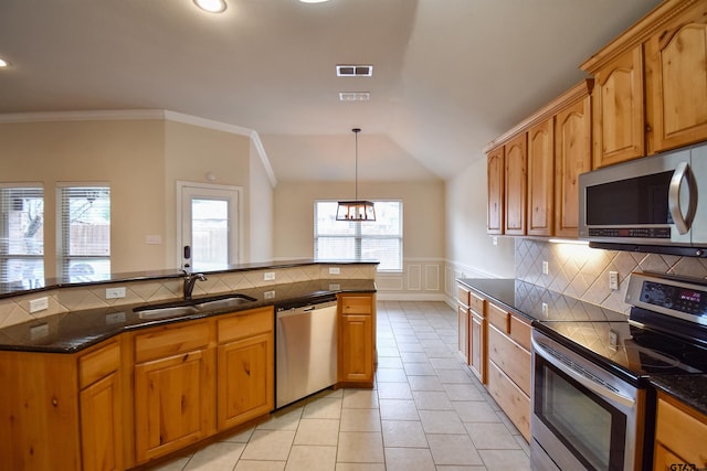 kitchen featuring light tile patterned flooring, lofted ceiling, sink, pendant lighting, and stainless steel appliances