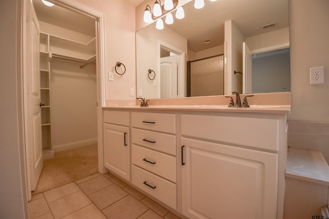 bathroom with tile patterned flooring, vanity, and an enclosed shower