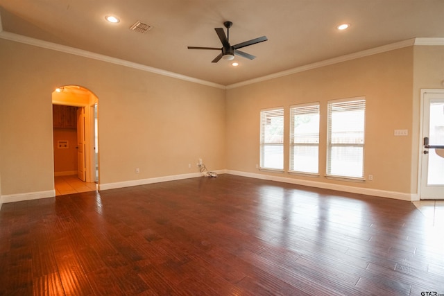 spare room with visible vents, ornamental molding, arched walkways, a ceiling fan, and dark wood-style flooring