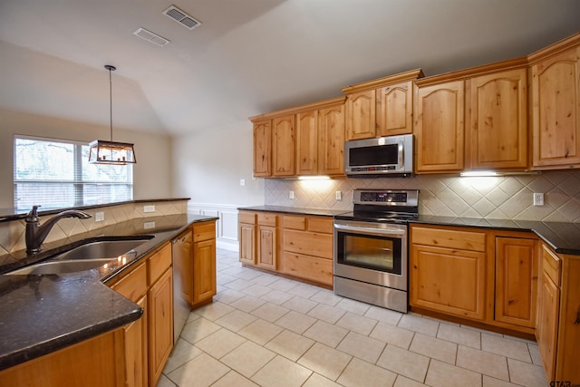 kitchen featuring sink, appliances with stainless steel finishes, tasteful backsplash, decorative light fixtures, and vaulted ceiling