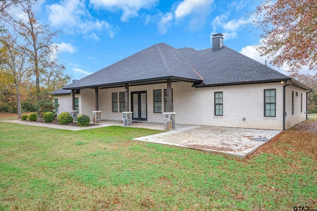 back of property featuring a lawn and a patio