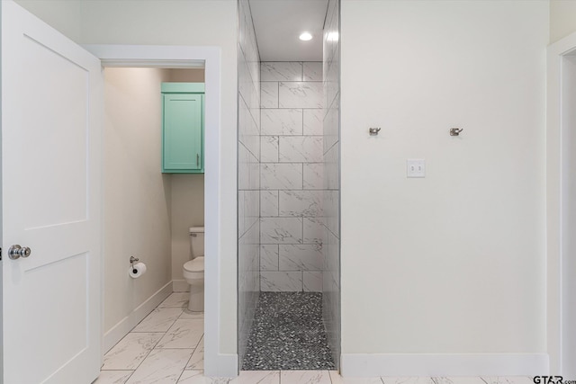 bathroom with tiled shower and toilet