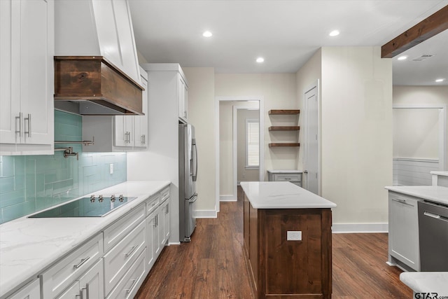 kitchen with white cabinetry, beamed ceiling, backsplash, a kitchen island, and appliances with stainless steel finishes