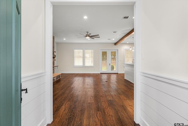 unfurnished living room with beam ceiling, french doors, dark hardwood / wood-style floors, and ceiling fan