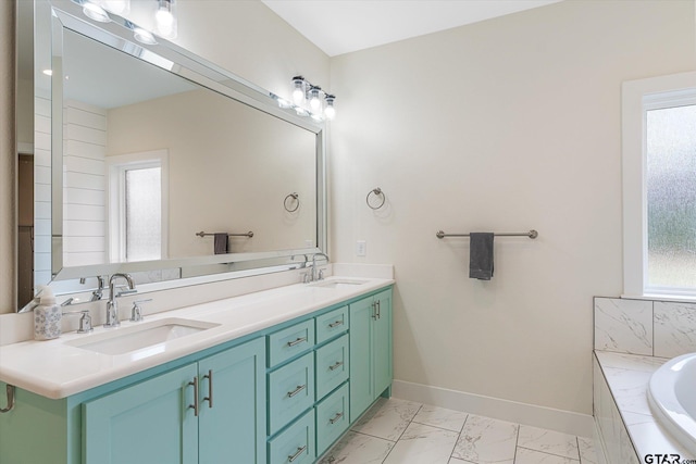 bathroom featuring tiled tub and vanity