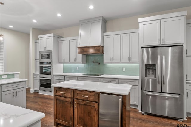 kitchen featuring pendant lighting, premium range hood, decorative backsplash, dark hardwood / wood-style flooring, and stainless steel appliances