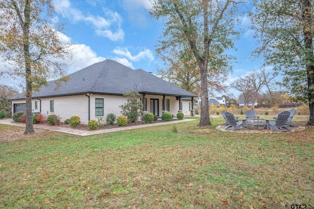 exterior space featuring an outdoor fire pit and a lawn