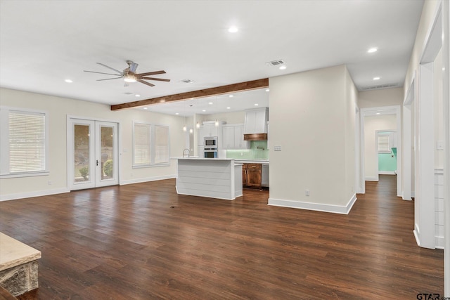 unfurnished living room with dark wood-type flooring, french doors, sink, ceiling fan, and beam ceiling