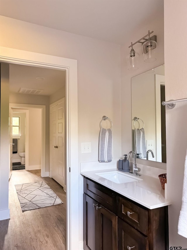 bathroom with vanity, hardwood / wood-style flooring, and toilet