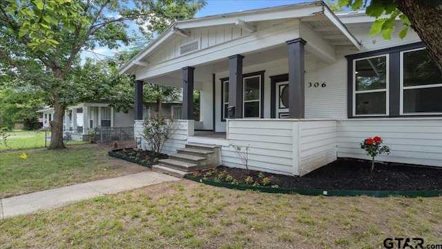 bungalow with a front lawn and covered porch