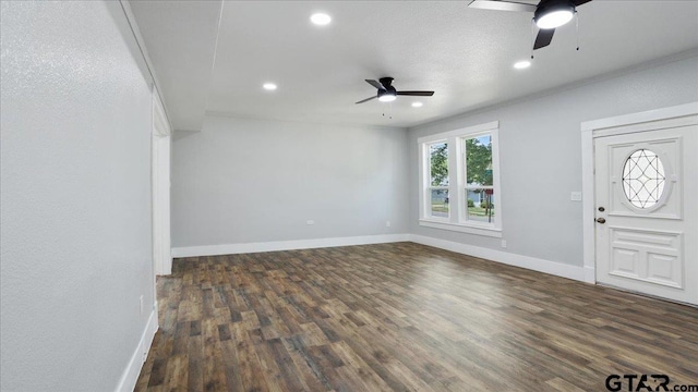 foyer entrance with ceiling fan, crown molding, and dark hardwood / wood-style flooring