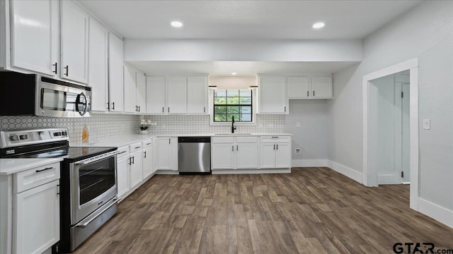 kitchen featuring dark hardwood / wood-style flooring, appliances with stainless steel finishes, sink, and white cabinets