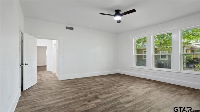 empty room with dark wood-type flooring and ceiling fan