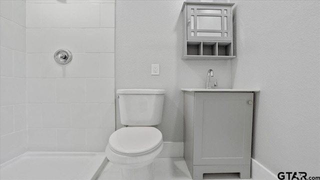 bathroom featuring toilet, a shower, and vanity