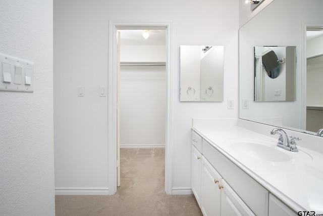1521 Rice Rd Unit E105, Tyler, TX 75703 - bathroom featuring vanity, a walk in closet, and baseboards