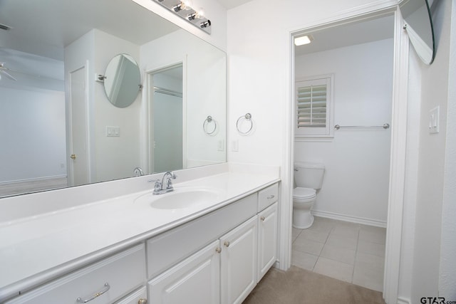 1521 Rice Rd Unit E105, Tyler, TX 75703 - bathroom with toilet, vanity, tile patterned floors, baseboards, and a ceiling fan