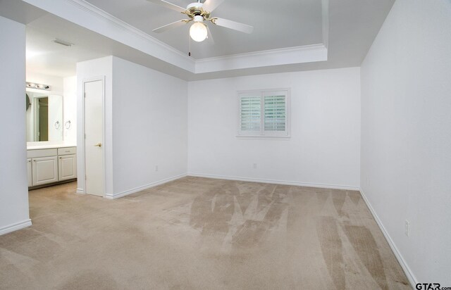 1521 Rice Rd Unit E105, Tyler, TX 75703 - empty room with light carpet, a raised ceiling, ceiling fan, baseboards, and ornamental molding