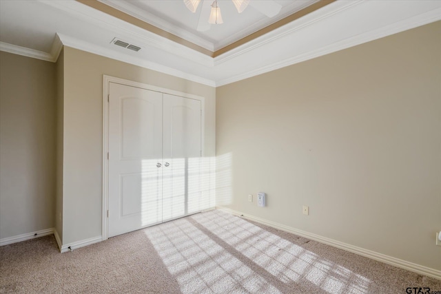 unfurnished bedroom with carpet floors, visible vents, ornamental molding, and baseboards