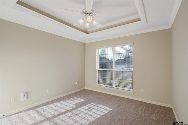 spare room with light carpet, baseboards, a ceiling fan, a tray ceiling, and crown molding