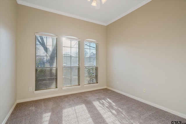 empty room featuring carpet floors, baseboards, ornamental molding, and ceiling fan