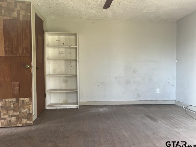 unfurnished bedroom with a textured ceiling, hardwood / wood-style floors, a ceiling fan, and baseboards