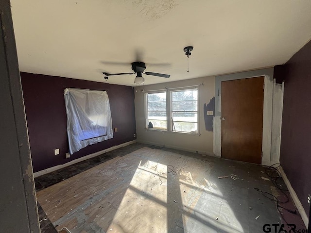 spare room with ceiling fan and baseboards