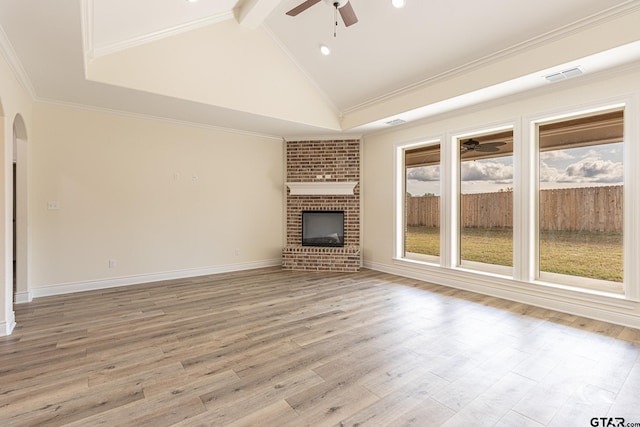 unfurnished living room featuring crown molding, ceiling fan, a brick fireplace, and light wood-type flooring