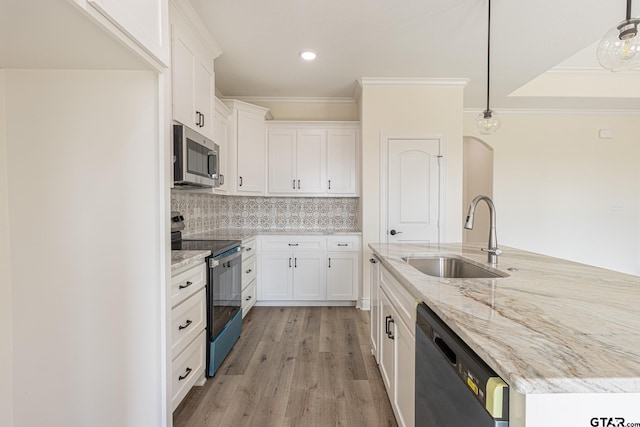 kitchen featuring stainless steel appliances, white cabinetry, sink, and decorative light fixtures