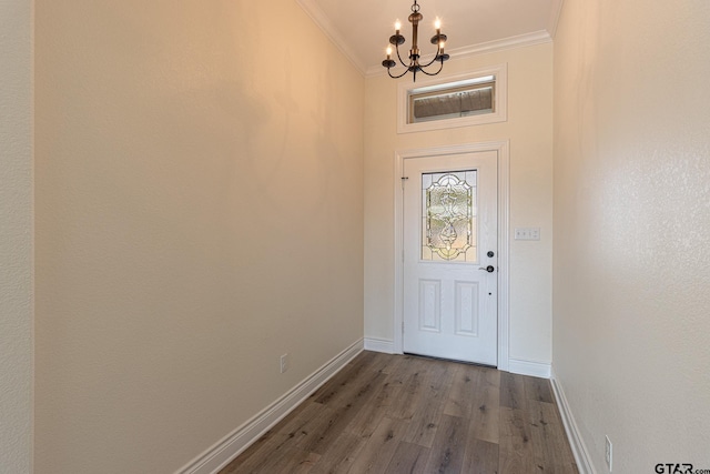 entryway with hardwood / wood-style floors, crown molding, and a chandelier